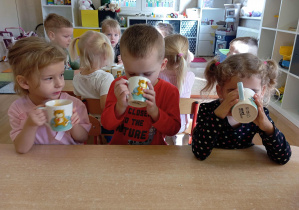 Dzieci smakują sok marchewkowy.