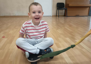 Chłopiec siedzi na deskorolce terapeutycznej