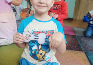 chłopiec pokazuje wylosowaną kość