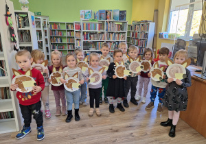 dzieci pozują do zdjęcia z wykonaną pracą