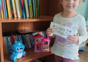 dziewczynka pozuje przy kąciku czytelniczym