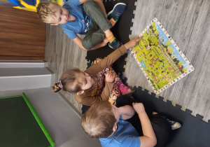 Helena wskazuje dzieci na obrazkach wyrażające odpowiednią emocję.