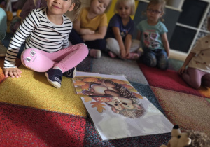 Dziewcczynka układa sylwetę jeża z czterech elementów.