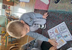 chłopiec kładzie obrazek na dywan