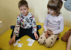 Dzieci w dwuosobowych zespołach układają puzzle z emocjami.