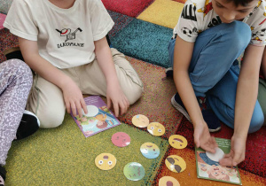 Chłopiec dopasowuje emocję do obrazka.