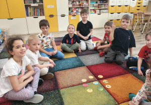 Dzieci przyglądają się żetonom z emocjami, nazywają je.