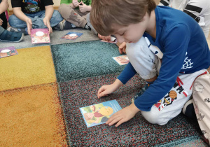 Chłopiec dopasowuje emocję do obrazka.