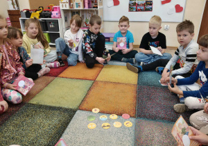 Dzieci obserwują i nazywają emocje na żetonach.