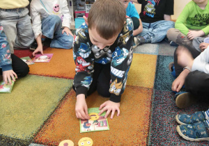 Chłopiec dopasowuje emocję do obrazka.