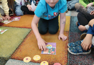 Chłopiec dopasowuje emocję do obrazka.