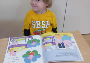 Chłopiec ogląda książkę.