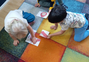 Dzieci układają postać Czerwonego Kapturka z czterech elementów.