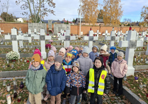 Dzieci stoją przy grobach