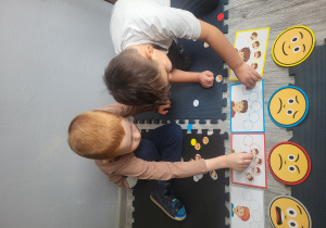 Chłopcy układają obrazki pod odpowiednią emocją.