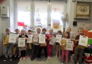 Nagrodzone dzieci na tle swoich prac.