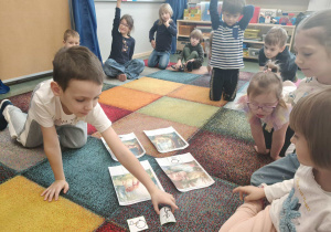 Chłopiec dopasowuje piktogram do właściwej ilustracji.