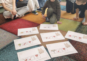 Chłopiec czyta zdanie zapisane za pomocą piktogramów.