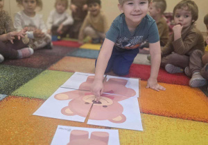 Chłopiec układa puzzle.