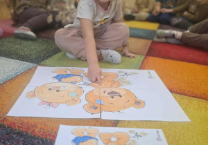 Dziewczynka układa puzzle.