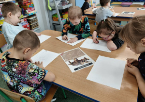 Dzieci wykonuja prace plastyczną węglem.