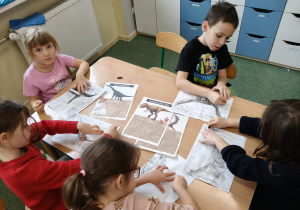 Dzieci wykonuja prace plastyczną węglem.