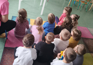 Dzieci oglądaja film edukacyjny o dinozaurach.