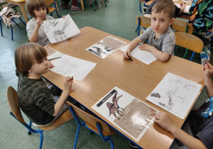 Dzieci wykonuja prace plastyczną węglem.