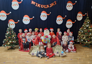 dzieci pozują do zdjęcia z Mikołajem