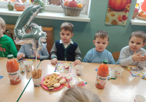 dzieci siedzą za stołem