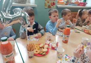 dzieci jedzą słodki poczęstunek