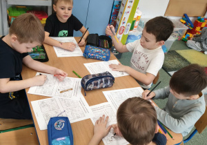 Dzieci kolorują na karcie pracy odpowiednie obrazki.