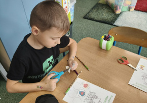 Chłopiec uzupełnia paszport o kolejną odznakę.