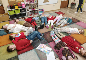 Dzieci wykonują ćwiczenie relaksacyjne.