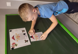 Marcel dobiera i układa obrazek z odp. emocją Mikołaja.