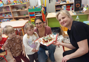 Dzieci rozdają własnoręcznie udekorowane pierniki innym grupom przedszkolnym.