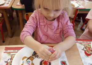 Dziewczynka dekoruje babeczkę.