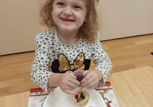 Dziewczynka dekoruje babeczkę.