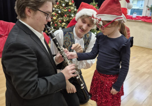 Dziewczynka wspólnie z muzykiem gra na klarnecie