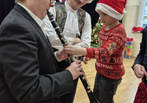 Chłopiec wspólnie z muzykiem gra na klarnecie