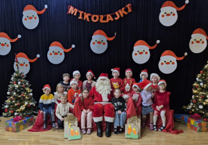 Dzieci pozują do zdjęcia z Mikołajem