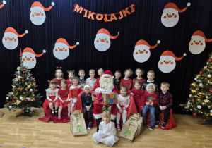 Dzieci pozują do zdjęcia z Mikołajem