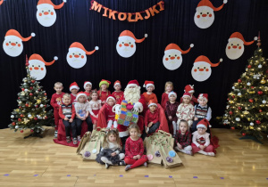 Dzieci pozują do zdjęcia z Mikołajem