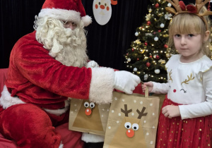 Mikołaj wręcza prezent dziewczynce