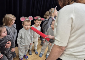 Pani dyrektor pasuje na przedszkolaka chłopca w stroju myszki