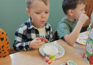 dzieci jedzą słodki poczęstunek