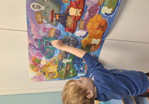 chłopiec przyczepia obrazek na plansze