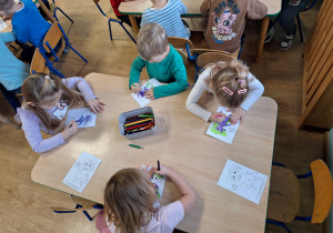 dzieci kolorują obrazek