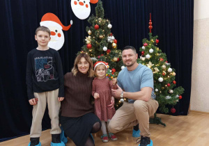 Rodzinne zdjęcie na tle choinki.