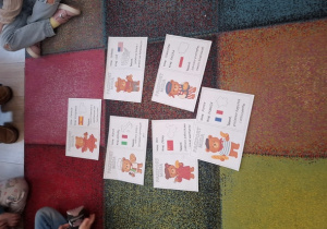 Ilustracje leżą na dywanie.